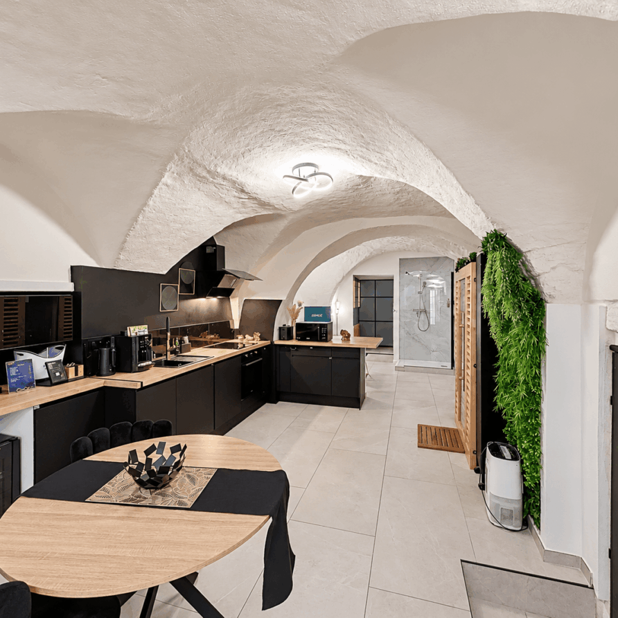 Séjour avec cuisine équipée et table à manger dans la suite LVRX à Gignac