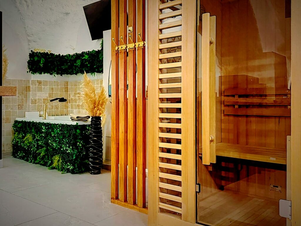 Sauna en bois et baignoire balnéo dans le spa privatif de la suite LVRX