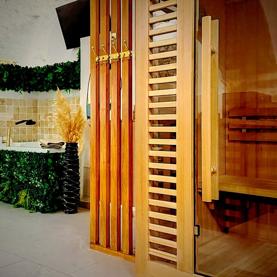 Sauna en bois et baignoire balnéo dans le spa privatif de la suite LVRX